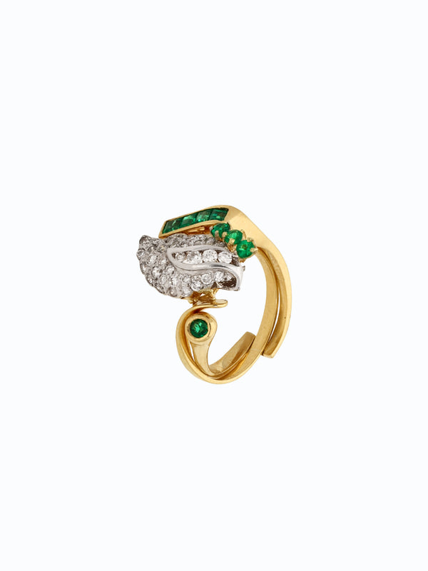 Anillo en oro 18k con esmeralda colombiana central y diamantes laterales. Fondo sobrio.
