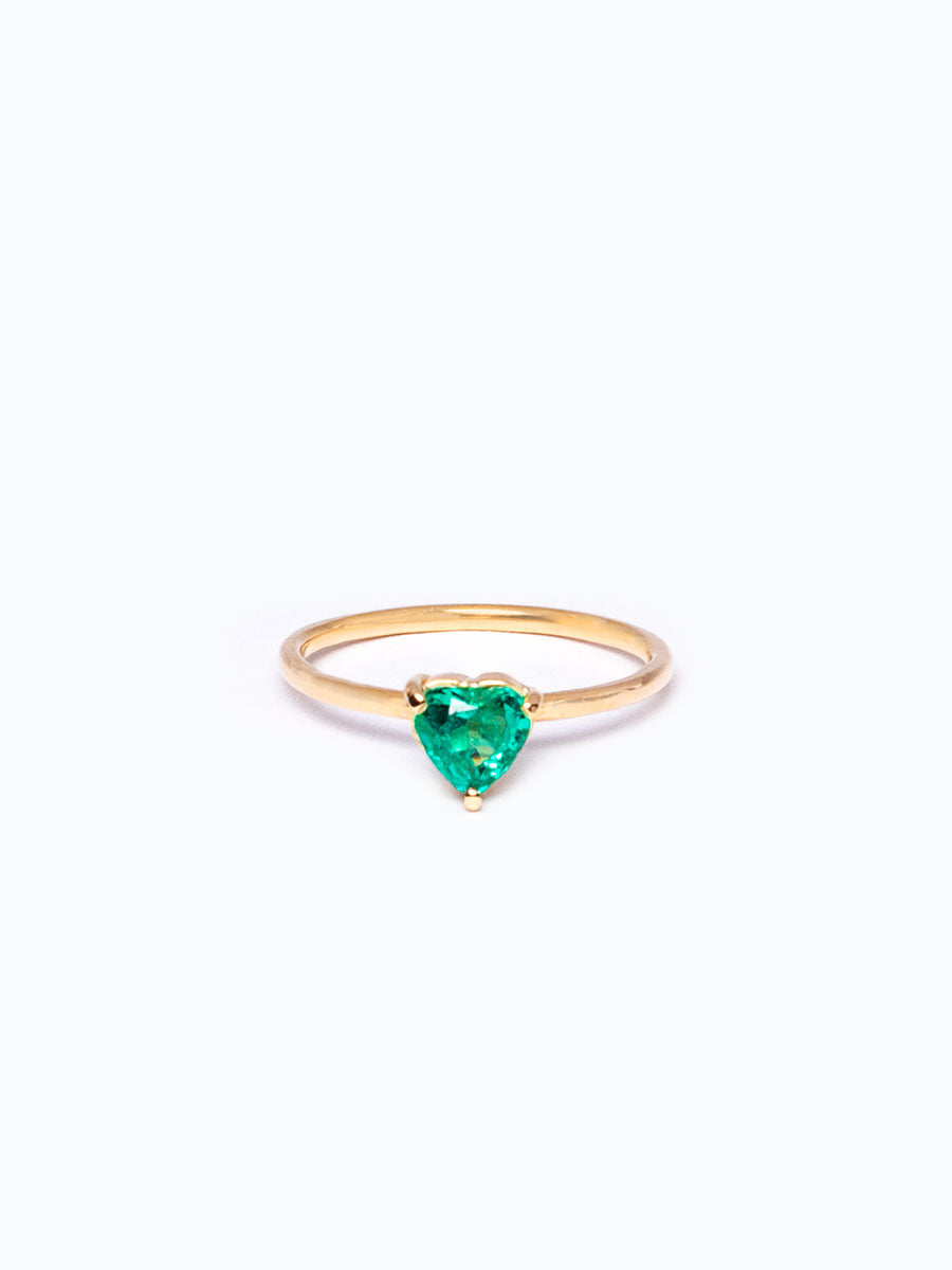 Anillo en oro 18k con esmeralda en forma de corazón, fondo neutro, diseño delicado