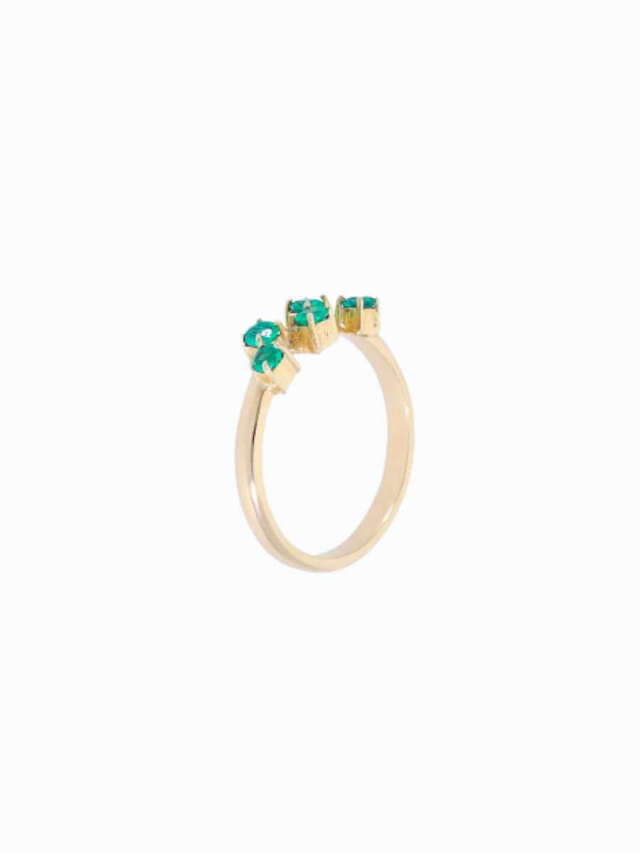 Anillo en oro 18 k con cinco esmeraldas talla brillante, fondo neutro, engaste delicado