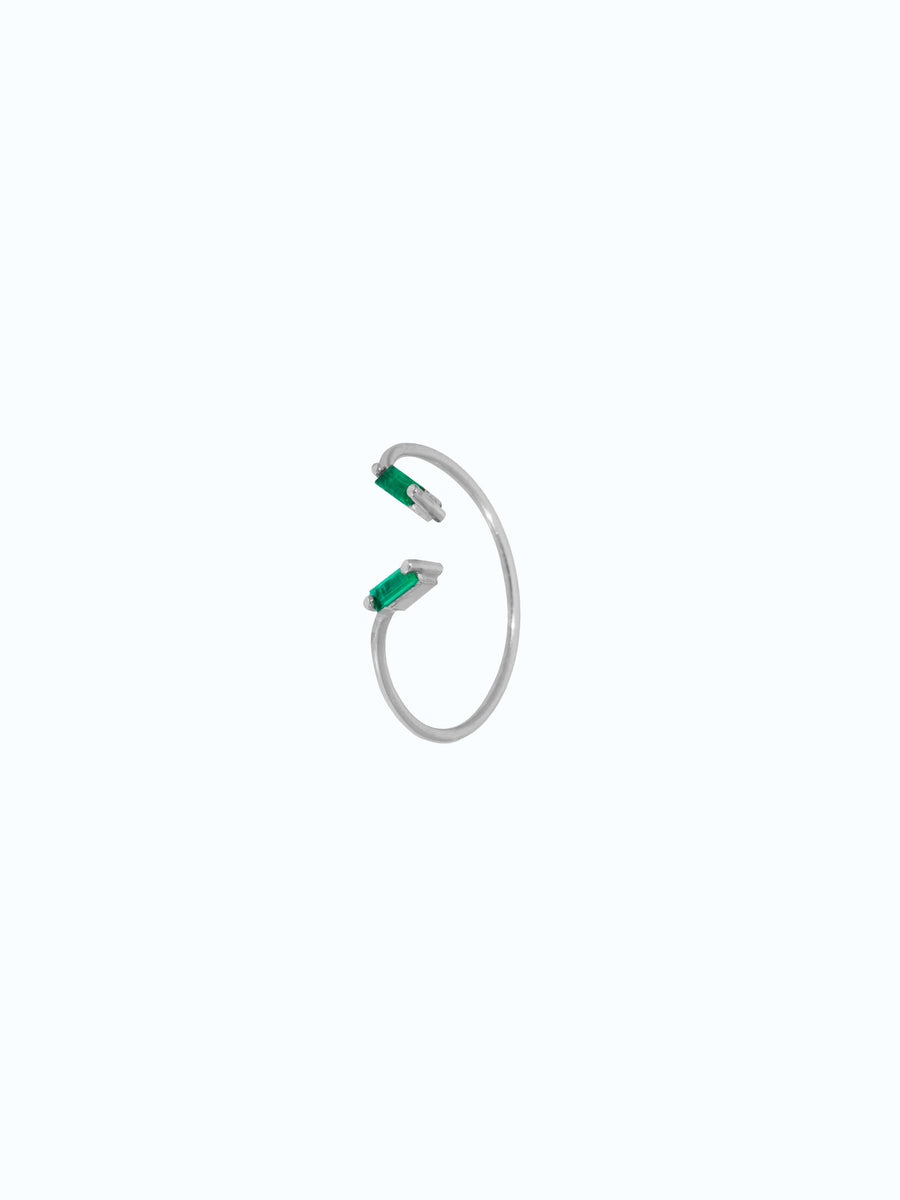 Detalle de anillo en oro blanco 18 k con dos esmeraldas talla baguette, fondo neutro