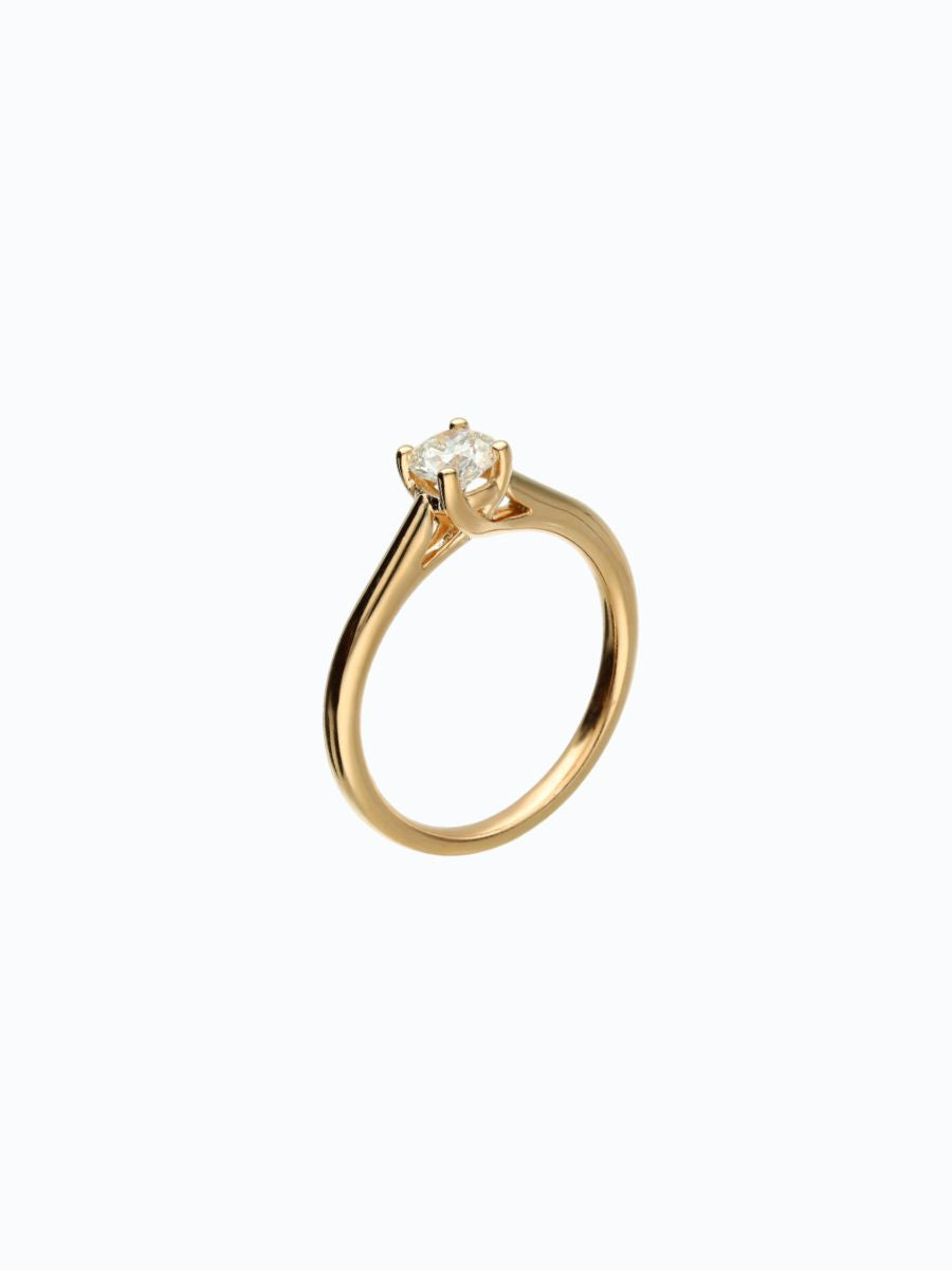 Anillo en oro amarillo 18 k con zircon central, fondo blanco, engaste clásico y limpio