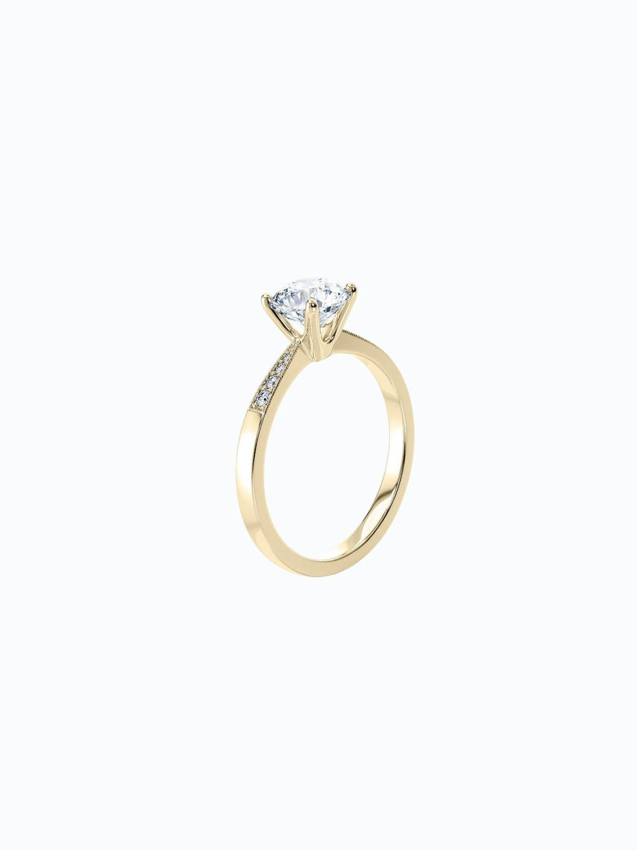 Anillo de oro amarillo de 18k con diamantes montados. Fondo claro, diseño elegante y simétrico.